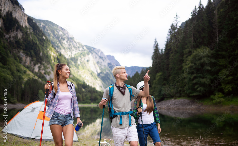 Group of friends hikers walking on a mountain at sunset