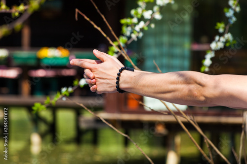 man hands in yoga symbolic gesture mudra outdoor shot closeup