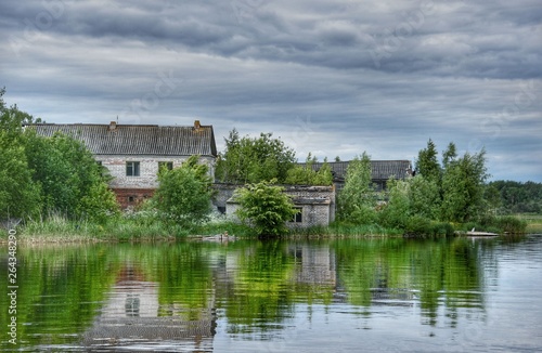 Gloomy landscape of old stone houses, gray rain clouds and reflecting coastal water