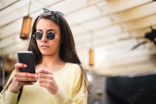 Girl in a yellow shirt taking a selfie. Teen with glasses taking a selfie. 