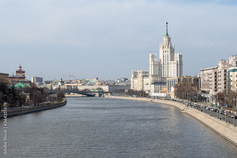 River embankment overlooking the bridge and the tall white building of Stalinist architecture River embankment overlooking the bridge and the tall white building of Stalinist architecture