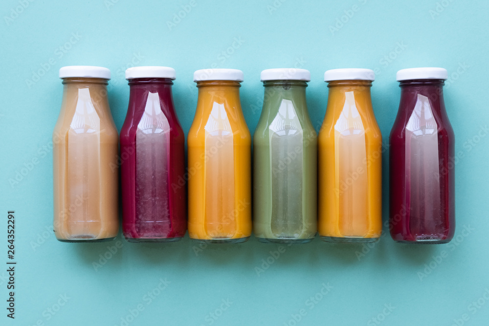 Fruit and vegetable juice bottles isolated on blue background. Natural Organic Food Style. Fruit and vegetable juice bottles isolated on blue background. Natural Organic Food Style.