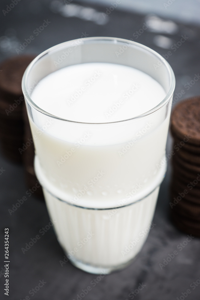 Glass of cold milk and chocolate cookies on the rustic background. Selective focus. Shallow depth of field. Glass of cold milk and chocolate cookies on the rustic background. Selective focus. Shallow depth of field.