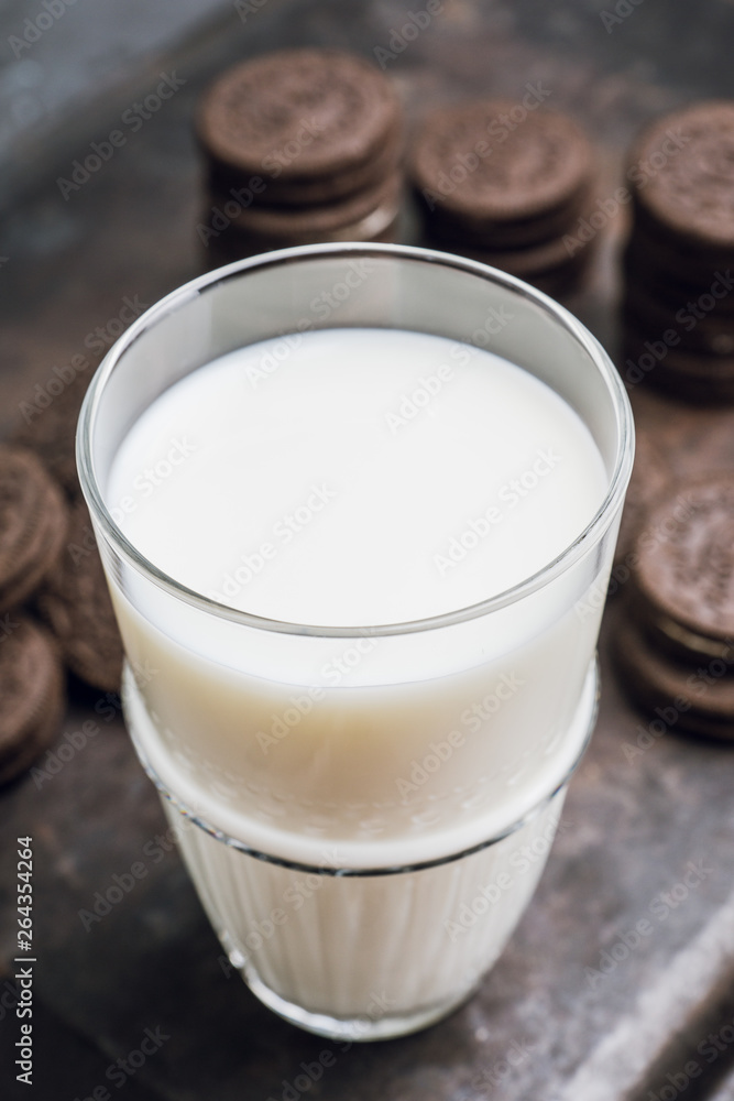 Glass of cold milk and chocolate cookies on the rustic background. Selective focus. Shallow depth of field. Glass of cold milk and chocolate cookies on the rustic background. Selective focus. Shallow depth of field.