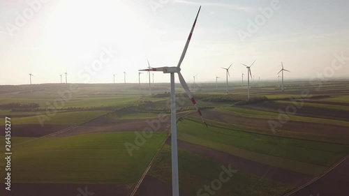 Windmills on agricultural area at countryside - Scenic drone shot at sunset of renewable energy photo