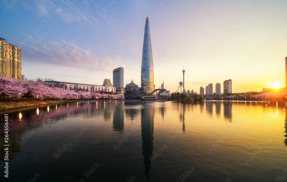 Sunrise over cherry blossom park and tower background