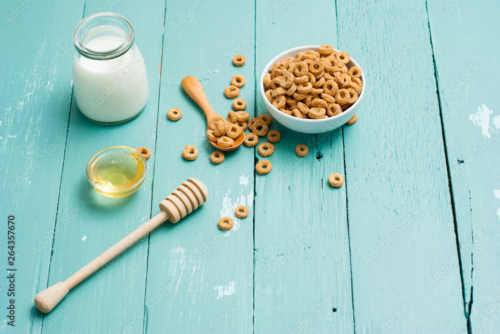 Fototapeta premium breakfast cereal with milk, honey on blue wood table