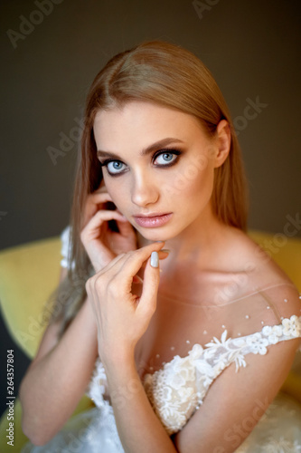 Portrait of a beautiful bride in a lace dress. Makeup smoky eyes, emphasis on eyes. Long flowing hair.