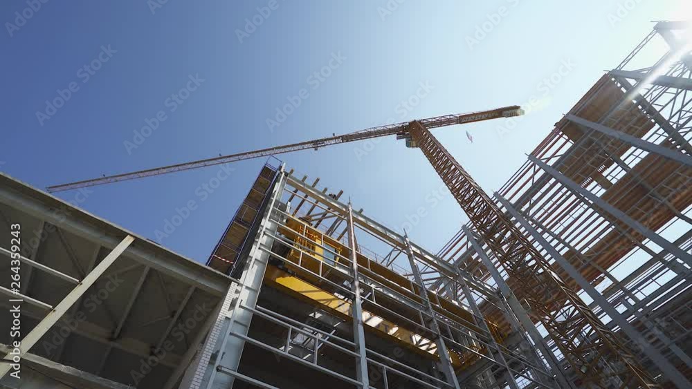 Construction of logistic buildings, bottom up view of steel floors and construction crane, camera motion. Construction of logistic buildings, bottom up view of steel floors and construction crane, camera motion.