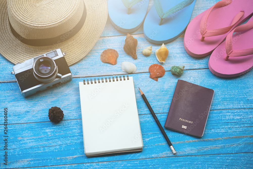 Flat lay design of travel to the sea concept with camera, hat, sandals,blank notebook and shell on blue wooden background. Flat lay design of travel to the sea concept with camera, hat, sandals,blank notebook and shell on blue wooden background.