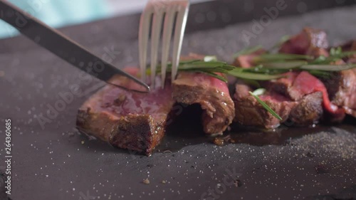 Filet Mignon is cut on a plate. Girl eating filet mignon.