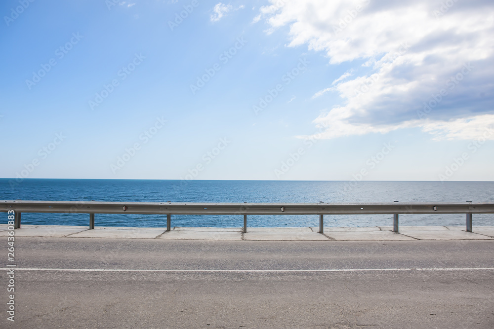 highway with fencing along the sea