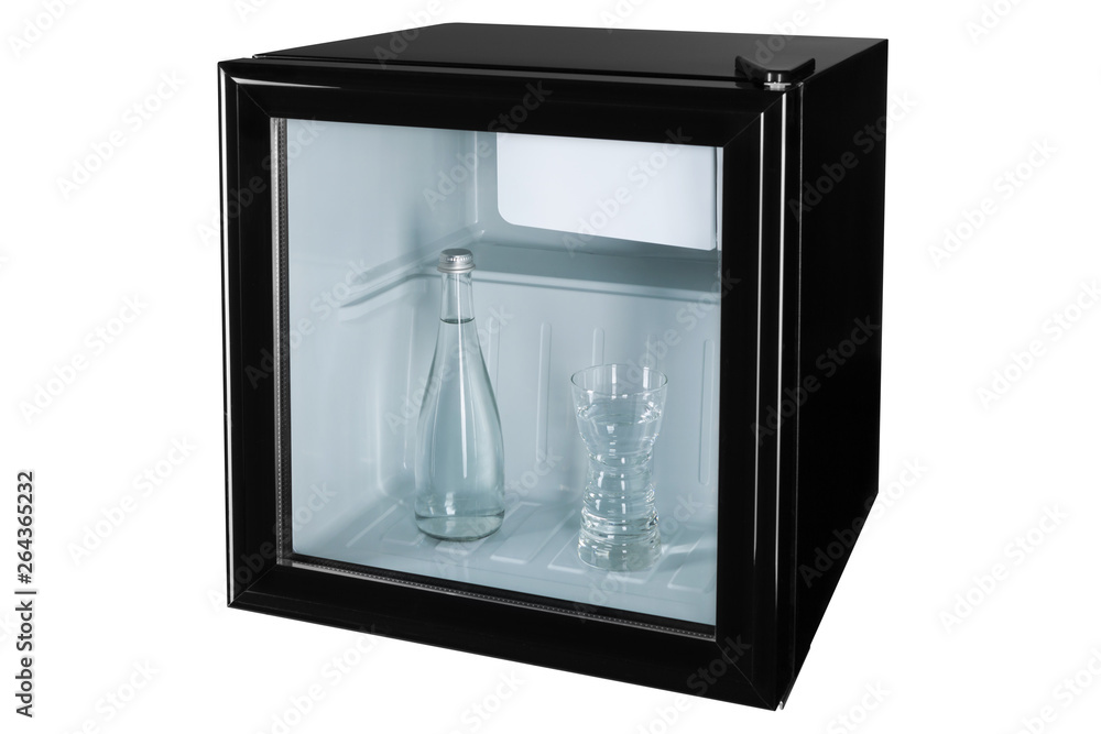 in a black mini bar or fridge with a glass door there is a glass bottle with water and a glass full of water, concept water and cooling, on a white background in a black mini bar or fridge with a glass door there is a glass bottle with water and a glass full of water, concept water and cooling, on a white background