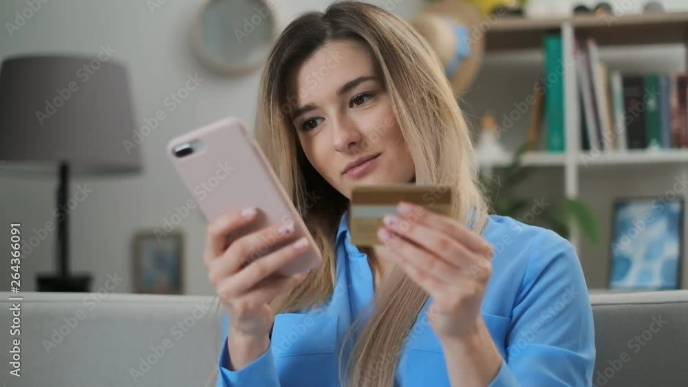 Woman making online payment with credit card usiing app and smartphone, online shopping, lifestyle technology. Girl enters the bank card number into the smart phone, easy pay using mobile device. Woman making online payment with credit card usiing app and smartphone, online shopping, lifestyle technology. Girl enters the bank card number into the smart phone, easy pay using mobile device.