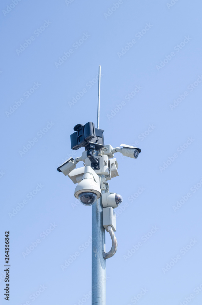Many dome and bullet formats security cameras for video surveillance on pole in sky Many dome and bullet formats security cameras for video surveillance on pole in sky