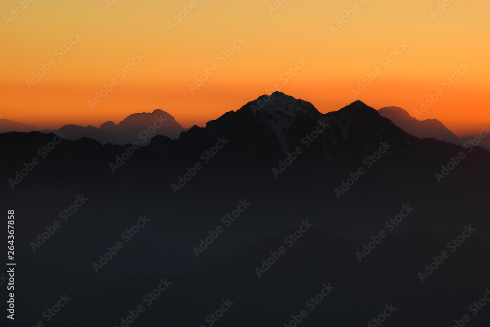Profili di montagne al tramonto rosso fuoco