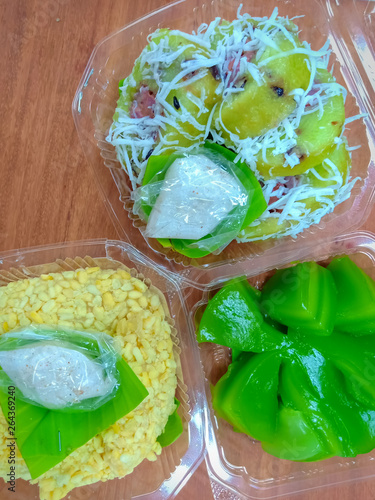 Thai dessert mixed in a plastic on wooden table background. 