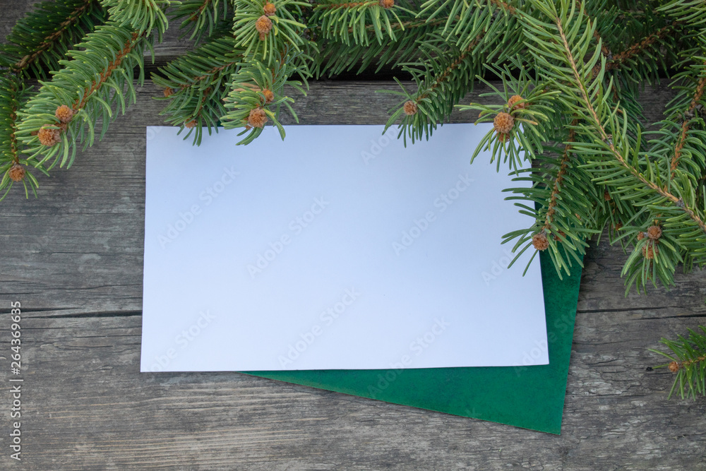 Fototapeta premium Green branches of a Christmas tree on the background of old, wooden boards. Top view with copy space.