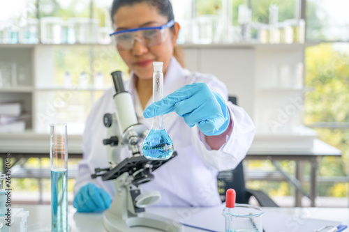 Fotografija Asian scientist in the laboratory working at lab with test tubes concept