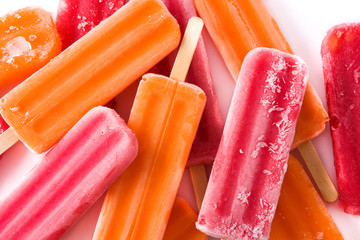 Orange and strawberry popsicles isolated on white background.
