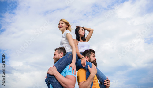 Couples on double date. Inviting another couple to join. Twice fun on double date. Friendship of families. Couples in love having fun. Men carry girlfriends on shoulders. Summer vacation and fun