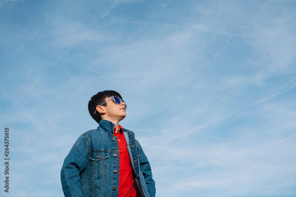 Happy kid with sunglasses in the field