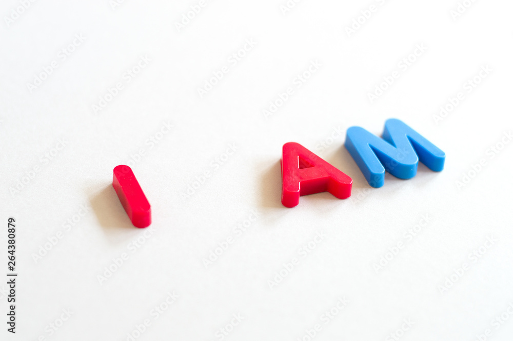 Phrase I am spelled with red and blue letters on white background Phrase I am spelled with red and blue letters on white background