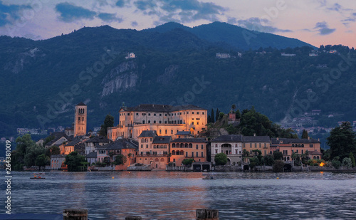 Orta Lake - Italy, suggestive view of San Giulio island in the evening while the first lights come on