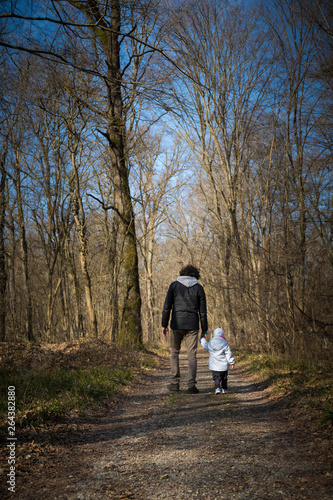 Dad and baby walking on country road.