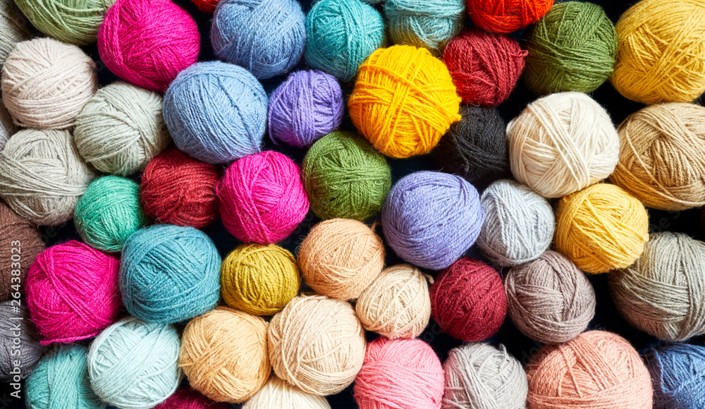 Colorful background made of many wool yarn balls. - obrazy, fototapety, plakaty 