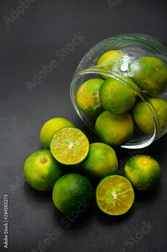 calamansi lime lying down on black background