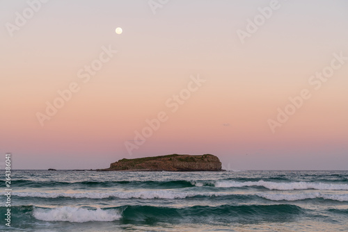 Vollmond über der Cook Island bei Sonnenuntergang und starkem Wellengang