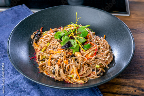 Buckwheat noodles with duck and mushrooms. Asian cuisine. The work of a professional chef. Dish from a restaurant or cafe menu. Close-up
