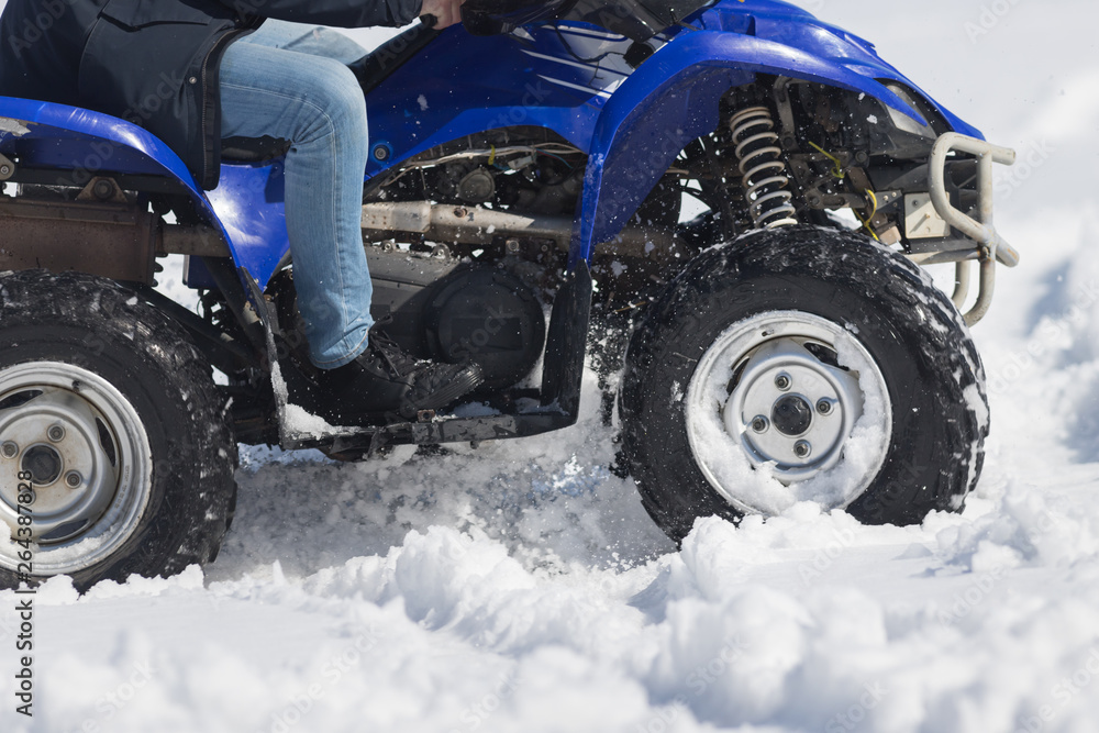 A person riding a bright blue snowmobile in the forest A person riding a bright blue snowmobile in the forest