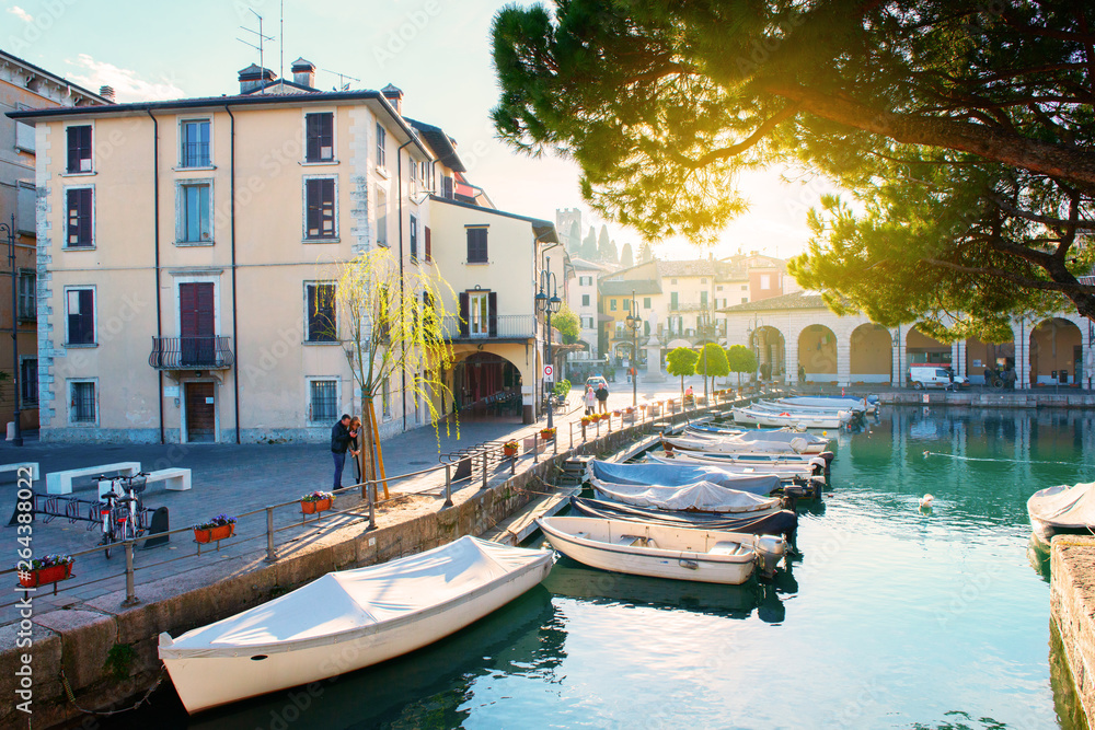 Desenzano del Garda, Italy. Calm beautiful view of italian lake Garda. Amazing landscape of ancient city, sky and mountains. Panorama of gorgeous Lake Garda, buildings and boats. Heaven on Earth.