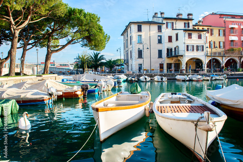 Desenzano del Garda, Italy. Calm beautiful view of italian lake Garda. Amazing landscape of ancient city, sky and mountains. Panorama of gorgeous Lake Garda, buildings and boats. Heaven on Earth. photo