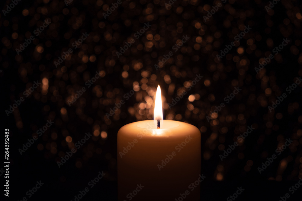burning candle in the dark on a brilliant background burning candle in the dark on a brilliant background