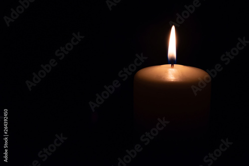 the candle burns on a black background