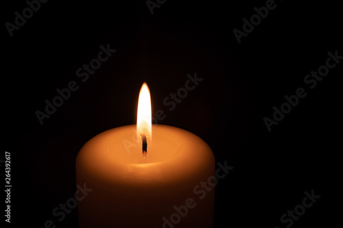 the candle burns on a black background