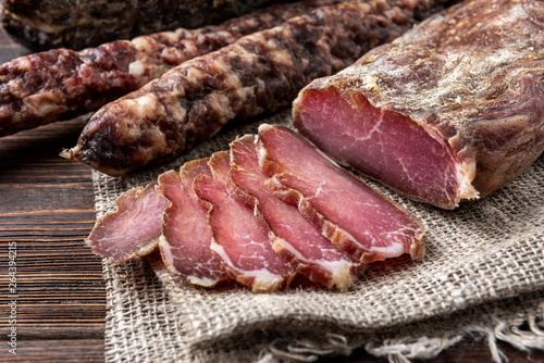 Photos Dried pork meat on dark wooden background