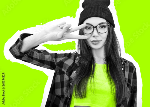 Young woman posing over vivid green background. Emotional female portrait. Hipster girl
