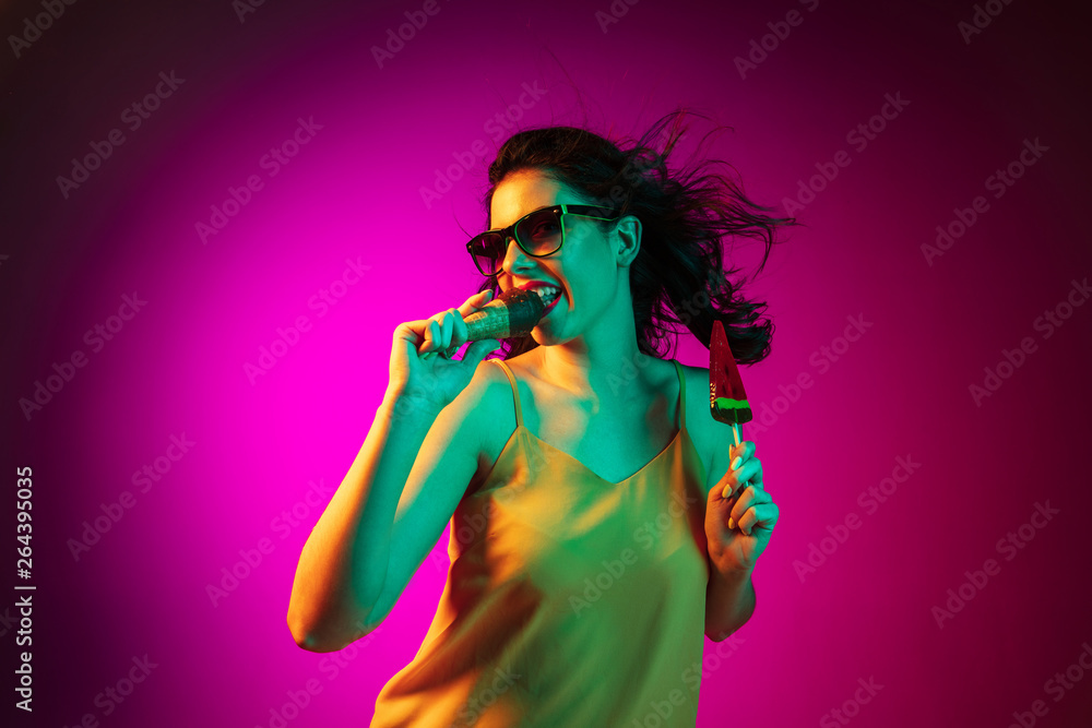 Happy young woman standing and smiling against pink background Happy young woman standing and smiling against pink background