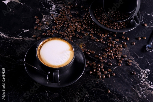 fresh flat white coffee on black marble table with coffee beans