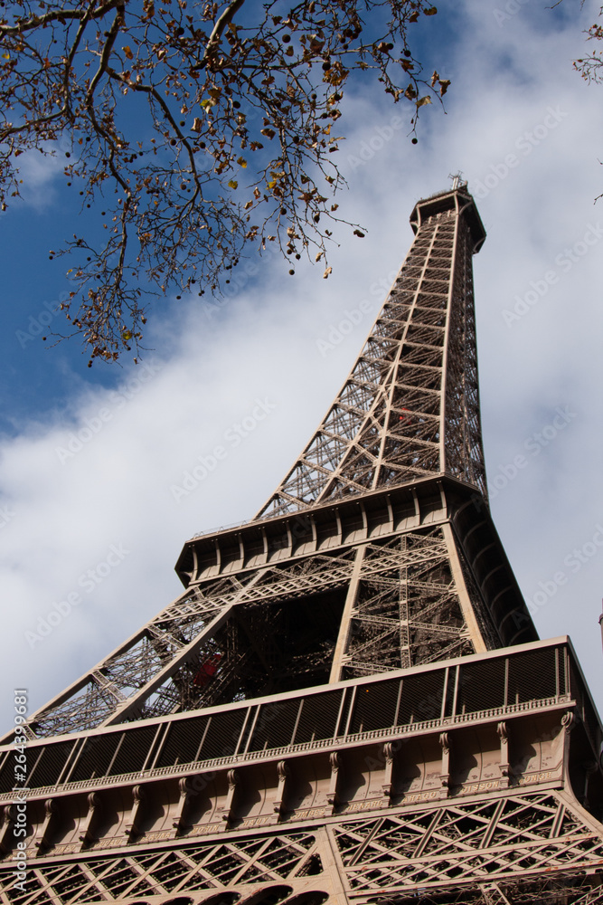 A low perspective of the Eiffel Tower with a blue sky on  an autumn day in Paris France