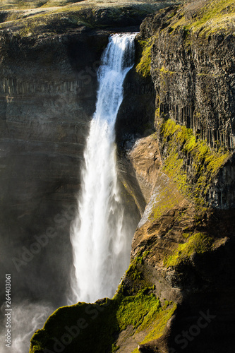 Haifoss waterfall and its gorge  mountains  rocks and mossy green valley of the waterfall and river. A view from a height from the edge of a cliff to a powerfull high furious waterfall  falling water.