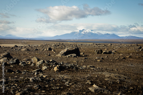 Stone desert, plain, emptiness, stones and mountains with snowy peaks in the background and blue sky with clouds above in Iceland. Alien landscape, dead land, dead and alien planet. Martian landscape.