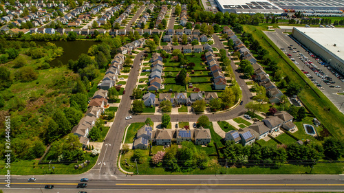 Suburban Neighborhood with Trees and Small Creek and Woods Aerial Drone View with Blue Sky