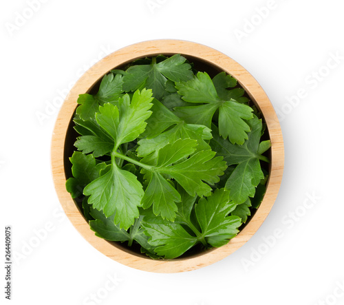 Parsley leaf in wood bowl isolated on a white background. top view