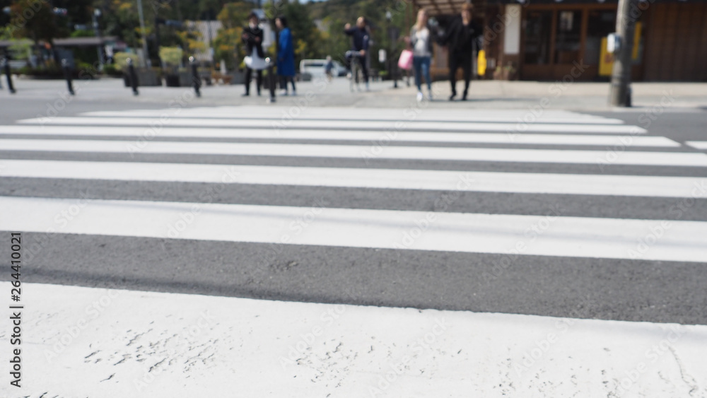 Blur crosswalk with tourists waiting at the opposite side.