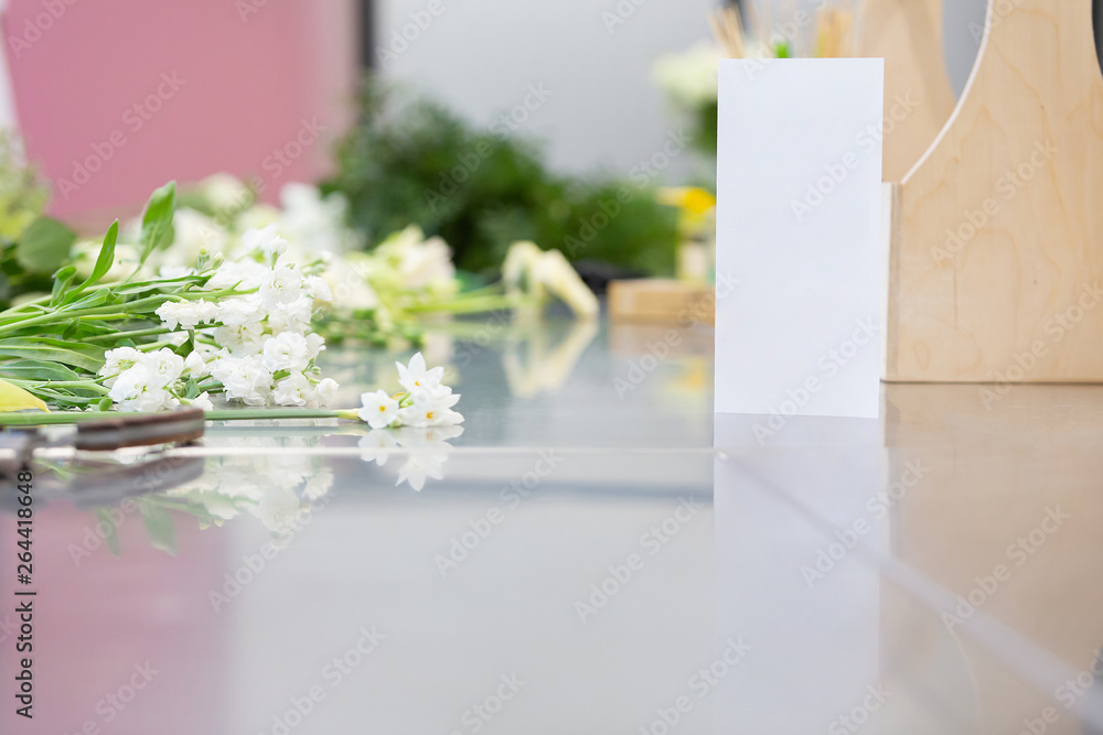Beautiful white flowers and florist's tools lie on a glossy gray table. Concept of master class for making beautiful flower bouquets Beautiful white flowers and florist's tools lie on a glossy gray table. Concept of master class for making beautiful flower bouquets